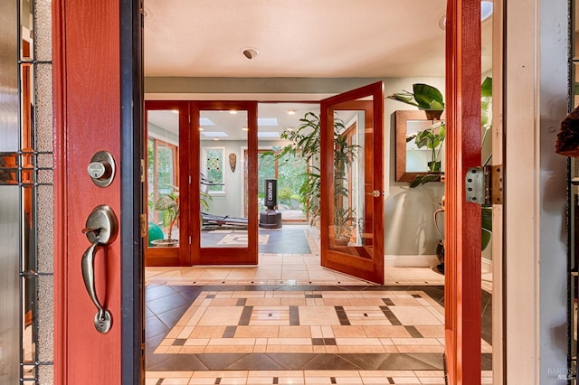 foyer entrance with tile patterned flooring, french doors, and baseboards