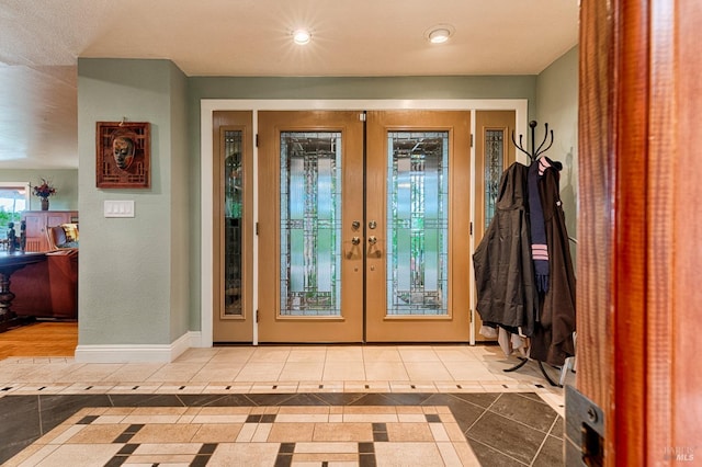 foyer with tile patterned floors, recessed lighting, french doors, and baseboards