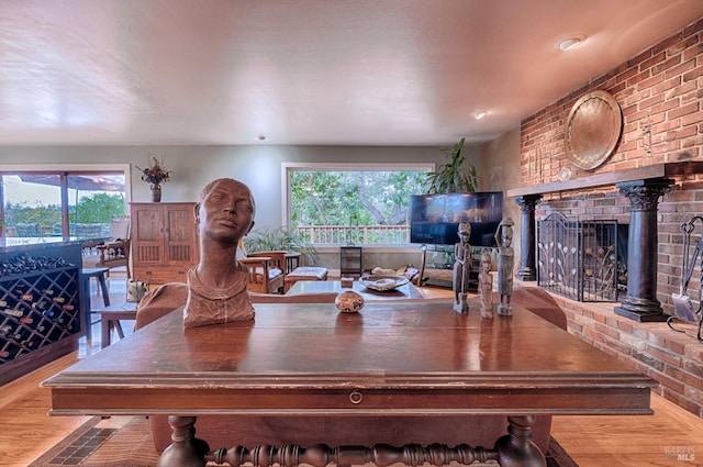 dining space featuring wood finished floors and brick wall