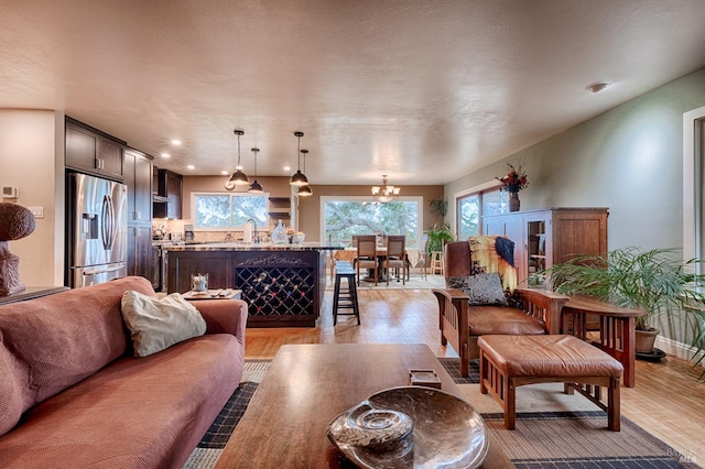 living room featuring light wood-style floors and a notable chandelier