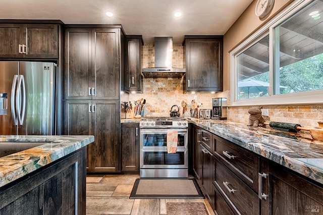 kitchen with decorative backsplash, dark brown cabinetry, wall chimney range hood, and stainless steel appliances