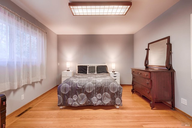 bedroom featuring light wood finished floors and visible vents