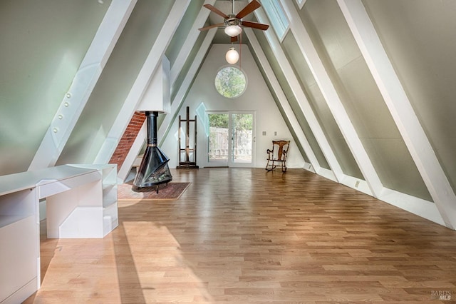 interior space with light wood-type flooring, high vaulted ceiling, a ceiling fan, and french doors