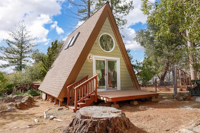 rear view of house featuring roof with shingles