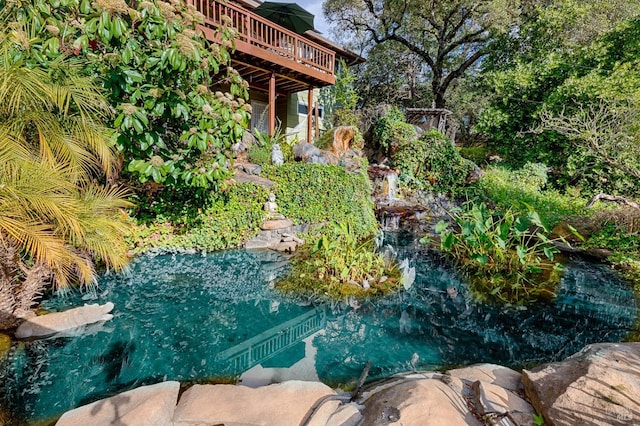 view of yard featuring a small pond and a wooden deck