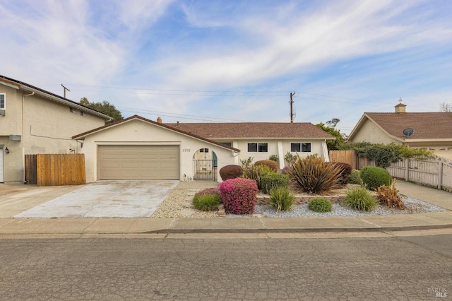 ranch-style home with an attached garage, fence, driveway, and stucco siding