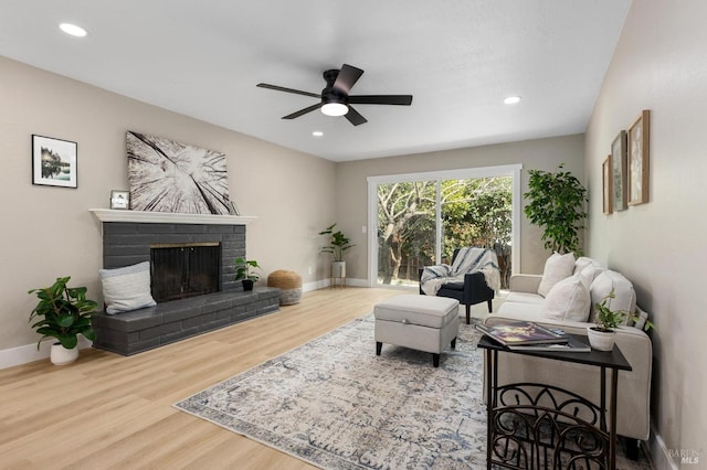 living room with recessed lighting, a fireplace, baseboards, and wood finished floors