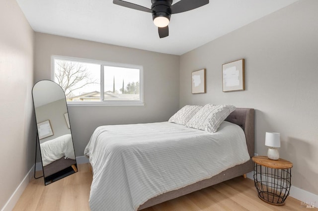 bedroom with baseboards, wood finished floors, and a ceiling fan