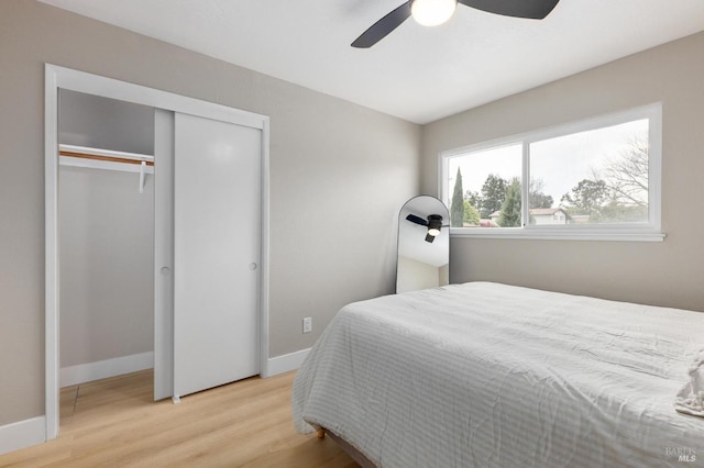 bedroom featuring a ceiling fan, baseboards, light wood-type flooring, and a closet