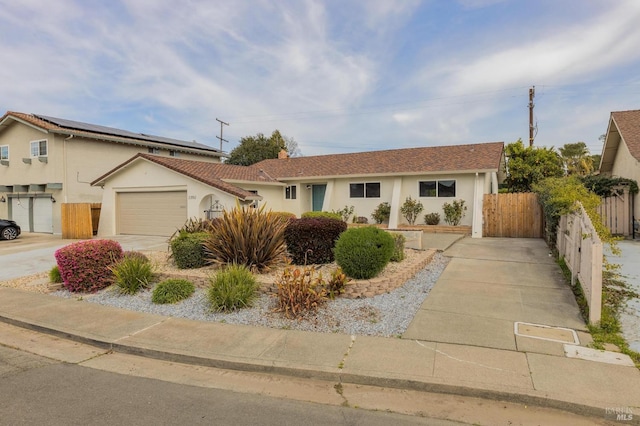 view of front of home featuring concrete driveway, fence, a garage, and stucco siding