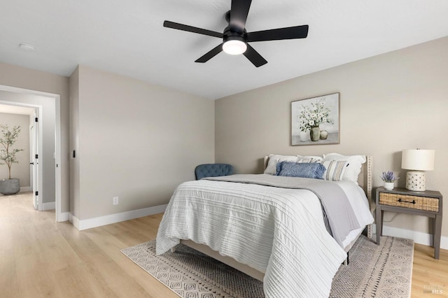 bedroom featuring light wood-style flooring, baseboards, and ceiling fan