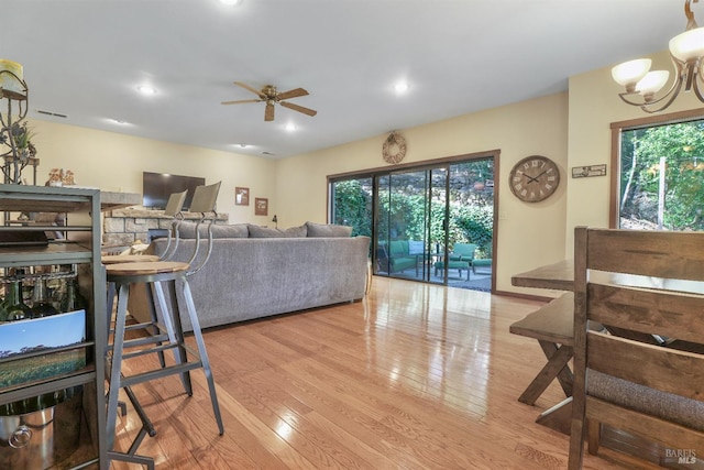 living room featuring recessed lighting, visible vents, wood finished floors, and ceiling fan with notable chandelier