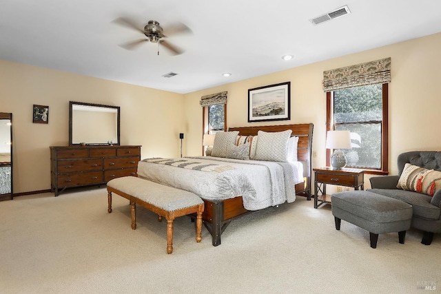 bedroom featuring baseboards, a ceiling fan, visible vents, and light carpet