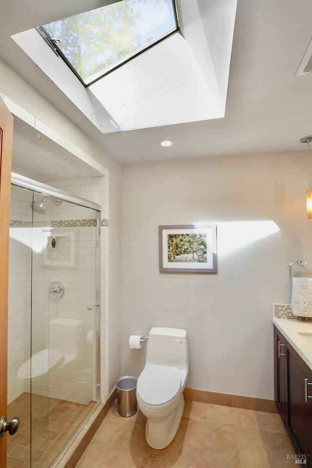 bathroom with vanity, baseboards, a shower stall, tile patterned floors, and toilet