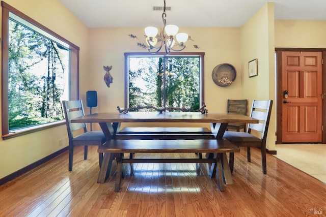 dining room with visible vents, baseboards, light wood-style floors, and a chandelier