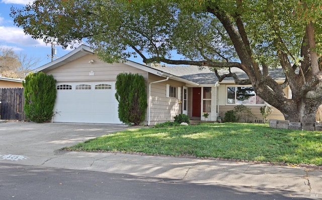 ranch-style home with a front yard, concrete driveway, a garage, and fence