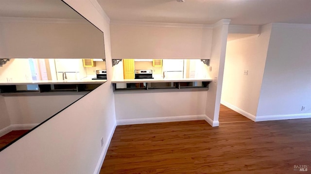 kitchen with stainless steel electric range oven, wood finished floors, baseboards, freestanding refrigerator, and ornamental molding