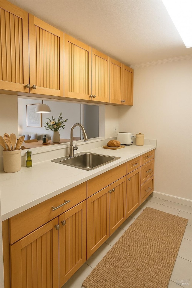 washroom featuring crown molding, light tile patterned flooring, and a sink