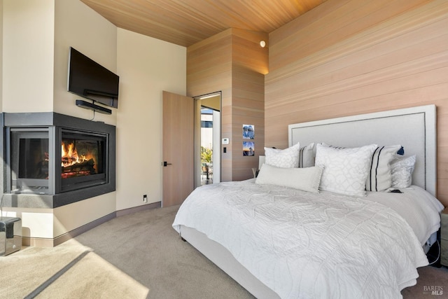 bedroom featuring wood walls, carpet flooring, wooden ceiling, baseboards, and a multi sided fireplace