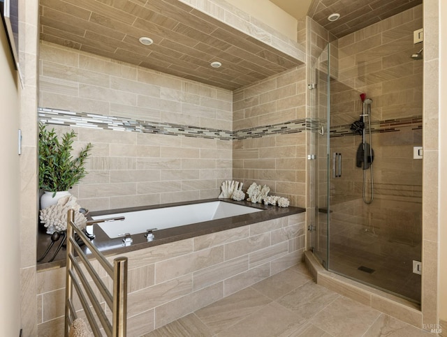 full bath featuring a stall shower, tile walls, and a garden tub