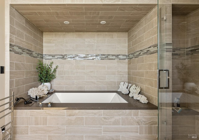 bathroom featuring a bath and a stall shower