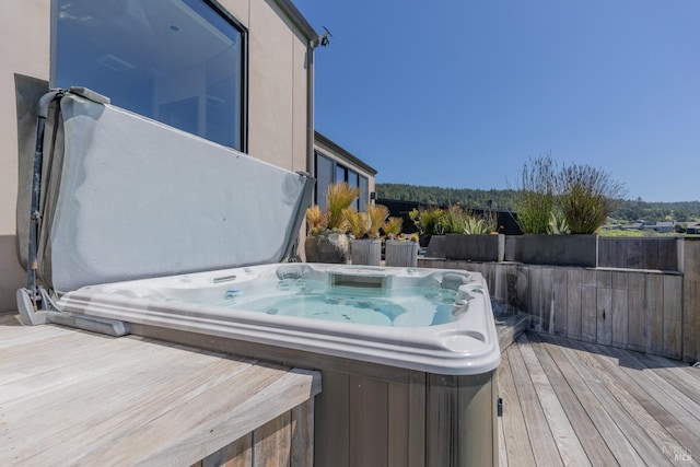 wooden deck featuring a covered hot tub