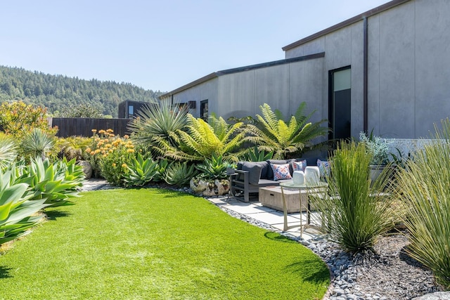 view of yard with fence, an outdoor living space, and a patio