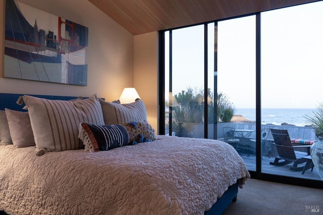 bedroom featuring a water view, access to exterior, vaulted ceiling, and carpet