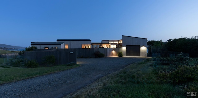 view of front of house with a fenced front yard and gravel driveway