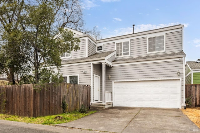 traditional-style home featuring driveway, an attached garage, and fence