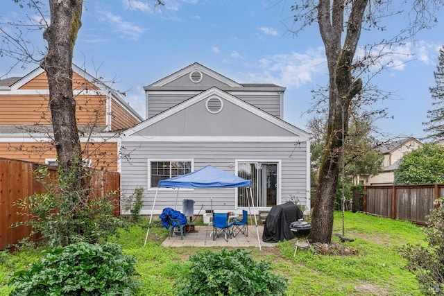 back of property with a yard, a patio, and a fenced backyard