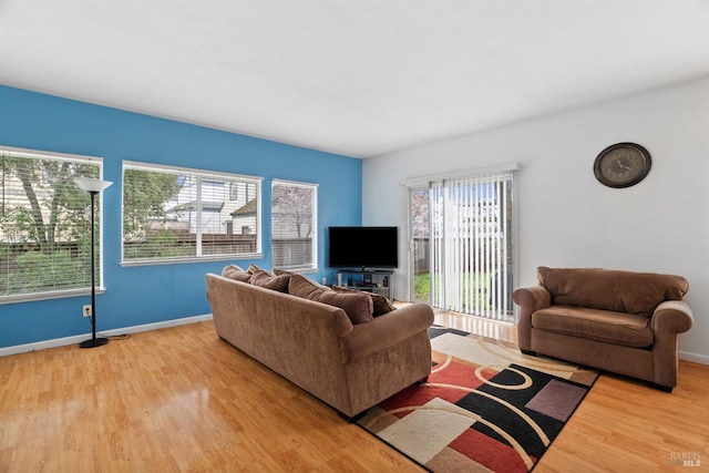 living area featuring baseboards and wood finished floors