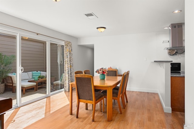 dining room with visible vents, light wood-style flooring, and baseboards