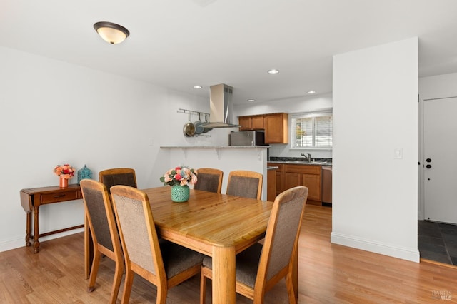 dining room featuring recessed lighting, light wood-type flooring, and baseboards