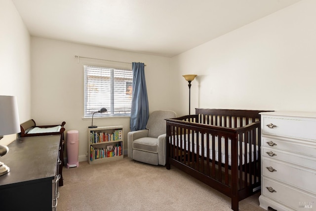 bedroom featuring a nursery area and light carpet