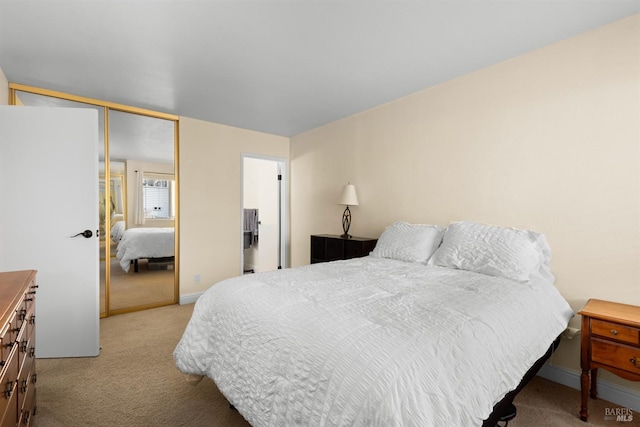 carpeted bedroom featuring baseboards and a closet