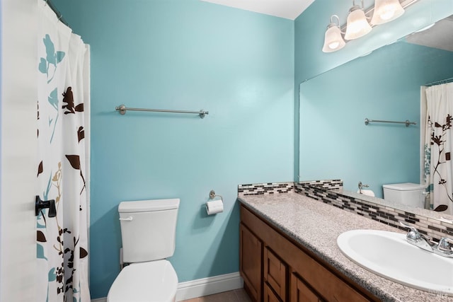 full bathroom featuring vanity, toilet, and baseboards