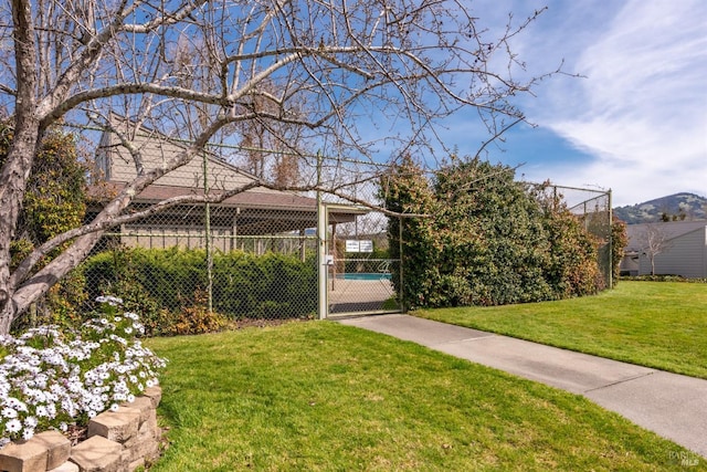 exterior space featuring fence, a lawn, and a gate