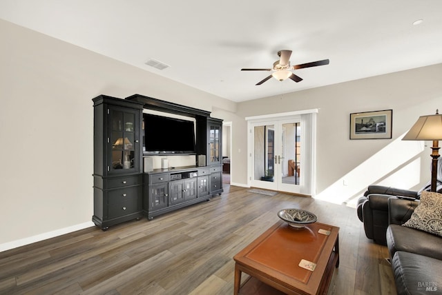 living area featuring a ceiling fan, wood finished floors, visible vents, baseboards, and french doors