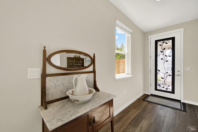 foyer entrance with dark wood finished floors and baseboards