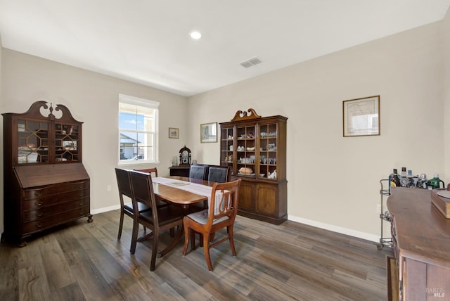 dining space with dark wood finished floors, visible vents, and baseboards