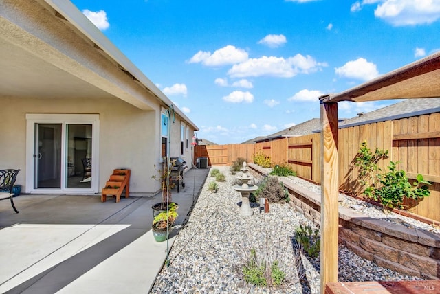 view of yard with central AC unit, a fenced backyard, and a patio area