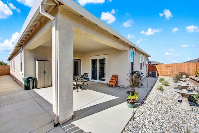 back of house featuring stucco siding, central air condition unit, a fenced backyard, and a patio area