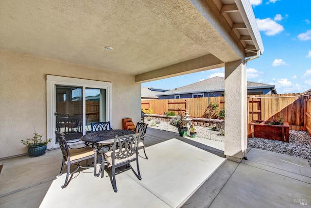 view of patio with outdoor dining space and fence