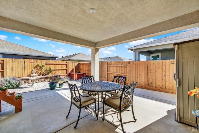 view of patio with outdoor dining space and fence