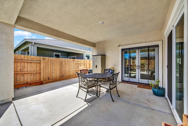 view of patio / terrace with outdoor dining space, fence, and french doors