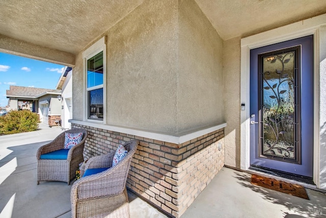 property entrance featuring brick siding and stucco siding