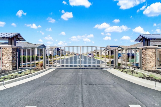 view of street featuring a residential view, a gated entry, and a gate