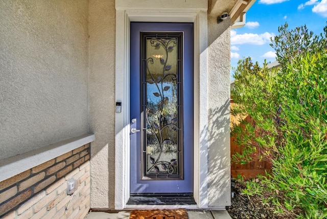 property entrance featuring stucco siding