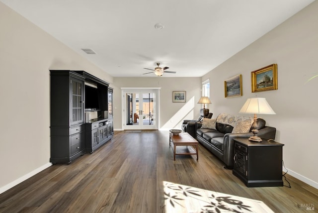 living area with visible vents, baseboards, ceiling fan, and wood finished floors